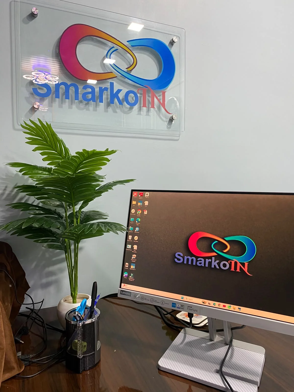 The actual SmarkoIn office with its branded wall display and workspace